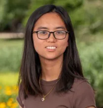 a young woman wearing glasses and a brown shirt