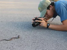 Justin Lee taking a photo of a snake