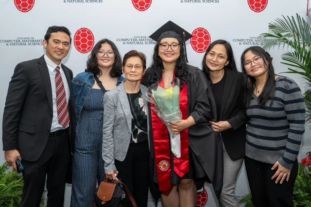 Graduate stands with family members