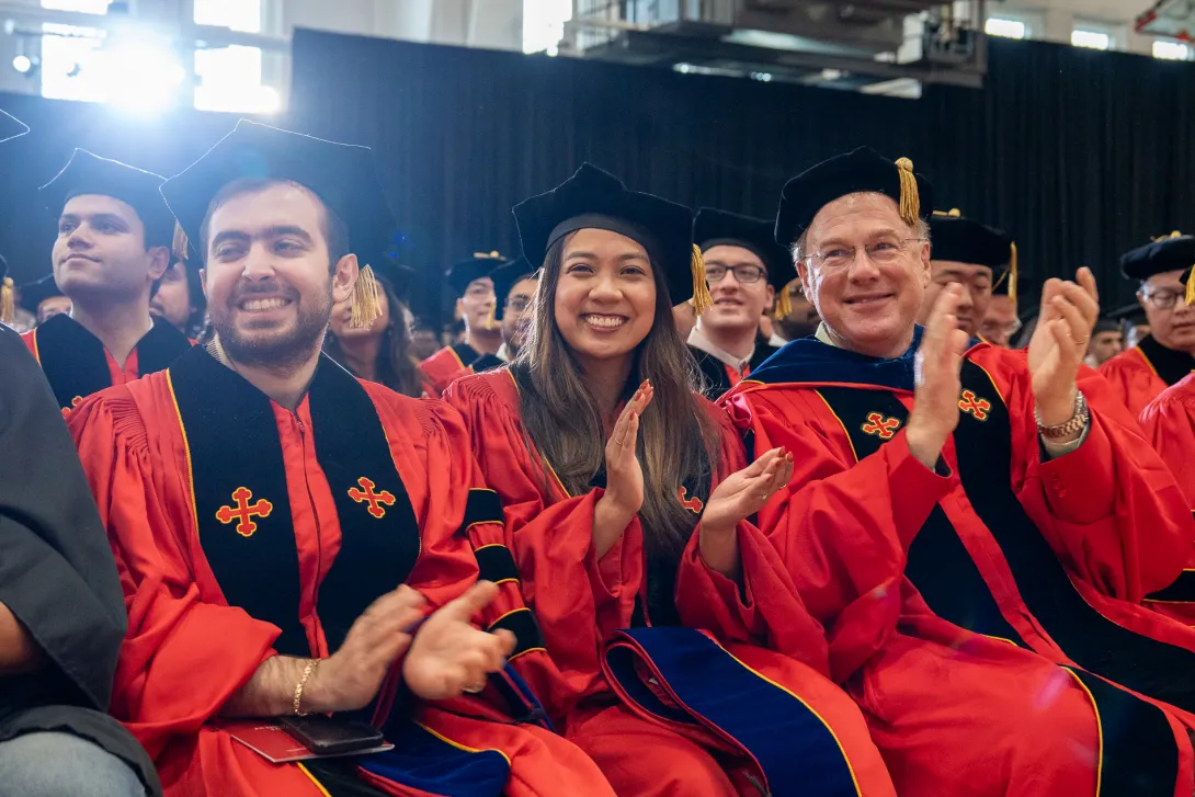 Graduates and faculty members clapping in the audience 