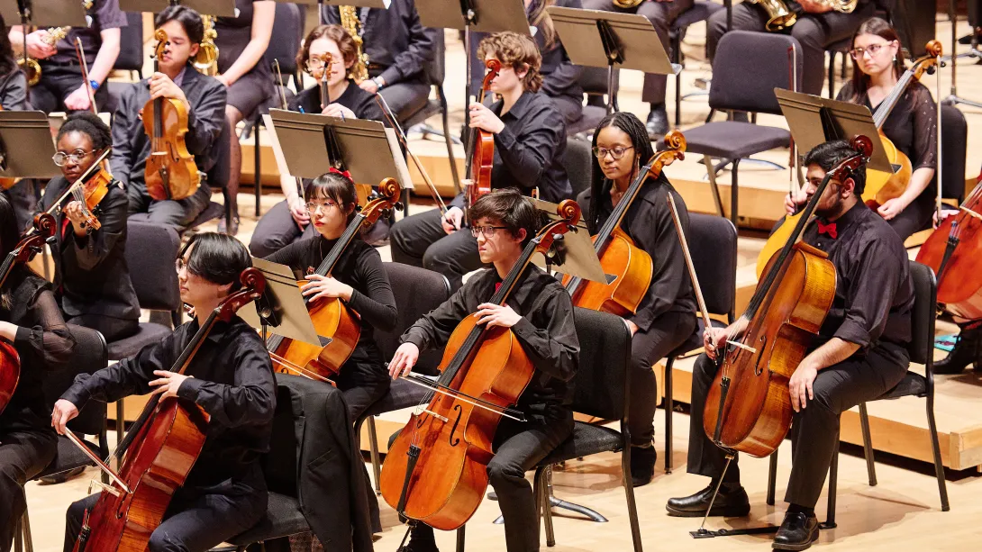 Cellists perform on stage.